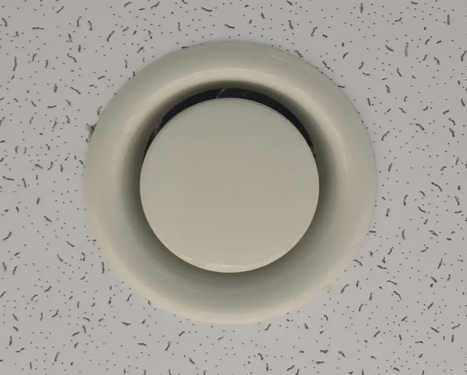 Round white disc valve in a ceiling