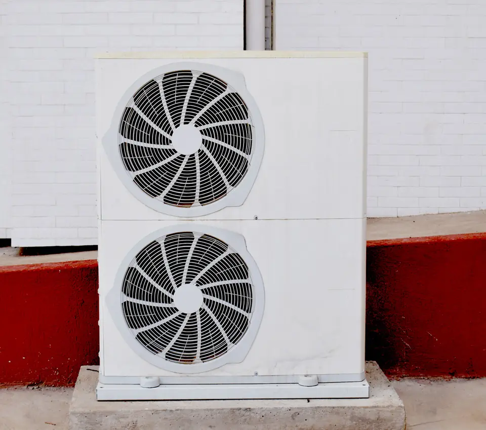 Outdoor unit with two fans installed against a wall