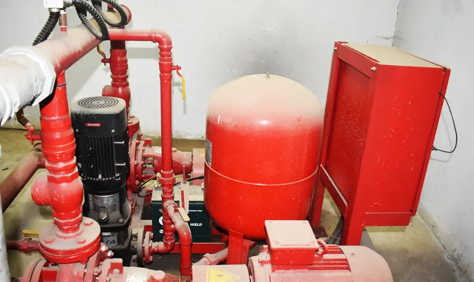 Fire pump set beside red pressure tanks