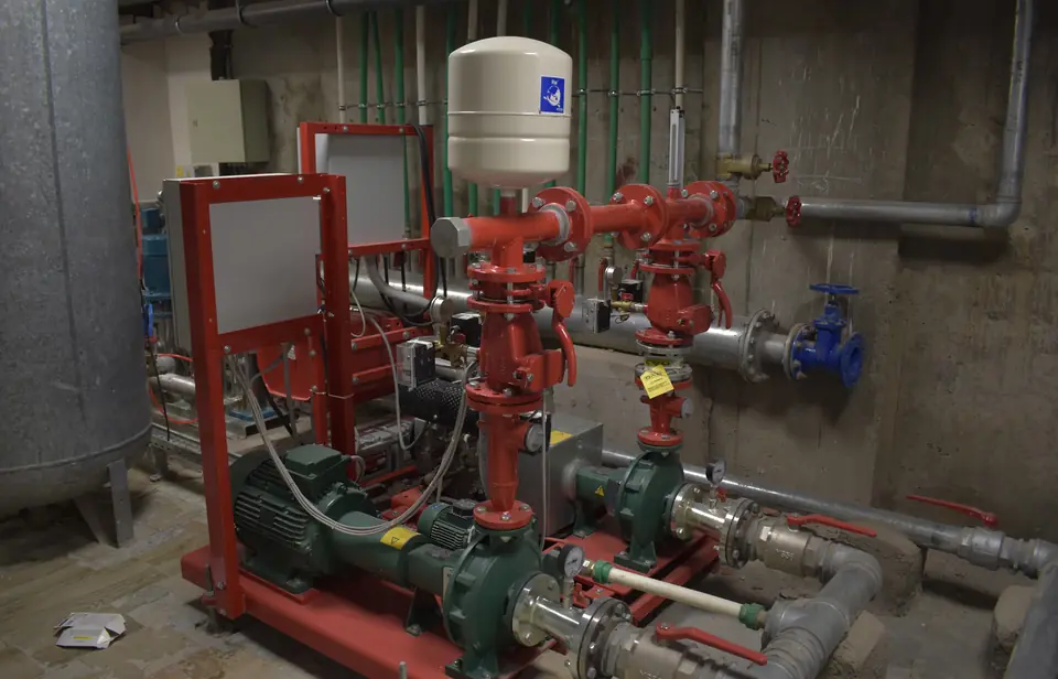 Fire pump set with red pipework and pressure vessel